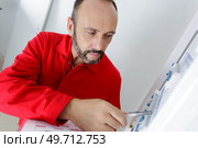 portrait of electrician standing next to fuseboard. Стоковое фото, агентство Ingram Publishing / Фотобанк Лори
