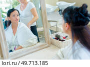 Mirror reflection of lady having hair styled. Стоковое фото, агентство Ingram Publishing / Фотобанк Лори