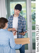young woman accepting parcel box from delivery man. Стоковое фото, агентство Ingram Publishing / Фотобанк Лори