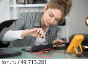 woman repairing computer part in service center. Стоковое фото, агентство Ingram Publishing / Фотобанк Лори