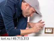 electrician mounting electric socket at building site. Стоковое фото, агентство Ingram Publishing / Фотобанк Лори