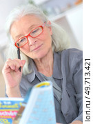 old woman playing crossword to maintain memory. Стоковое фото, агентство Ingram Publishing / Фотобанк Лори