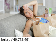 woman at home exhausted after doing the food shopping. Стоковое фото, агентство Ingram Publishing / Фотобанк Лори