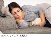 brunette sick woman laying on the couch. Стоковое фото, агентство Ingram Publishing / Фотобанк Лори
