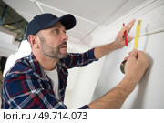 workman measuring ornate ceiling cornice. Стоковое фото, агентство Ingram Publishing / Фотобанк Лори
