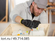 electrician preparing fuses in a circuit-breaker box. Стоковое фото, агентство Ingram Publishing / Фотобанк Лори