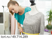seamstress measuring waist of mannequin. Стоковое фото, агентство Ingram Publishing / Фотобанк Лори