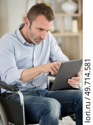 man in a wheelchair using a digital tablet. Стоковое фото, агентство Ingram Publishing / Фотобанк Лори