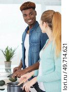 mixed couple preparing dinner in kitchen together. Стоковое фото, агентство Ingram Publishing / Фотобанк Лори