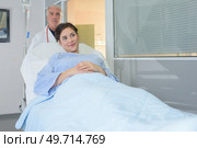 Doctor wheeling patient in hospital bed. Стоковое фото, агентство Ingram Publishing / Фотобанк Лори