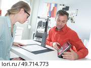 female pediatrician pointing at eye chart to child. Стоковое фото, агентство Ingram Publishing / Фотобанк Лори