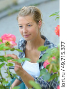 beautiful woman outdoors admiring a rose. Стоковое фото, агентство Ingram Publishing / Фотобанк Лори