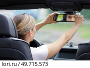 woman adjusting rearview mirror in the car. Стоковое фото, агентство Ingram Publishing / Фотобанк Лори
