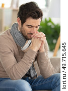 young handsome man begging and praying with hands together. Стоковое фото, агентство Ingram Publishing / Фотобанк Лори
