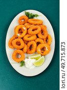 Baked breaded calamari rings served with lime. Top view. Deep fried squid rings on a plate. Стоковое фото, агентство Ingram Publishing / Фотобанк Лори
