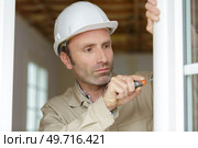 male builder screwing a window. Стоковое фото, агентство Ingram Publishing / Фотобанк Лори