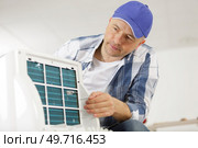 man repairing air conditioner with screwdriver. Стоковое фото, агентство Ingram Publishing / Фотобанк Лори