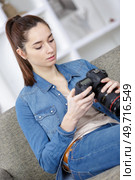 photographer woman with camera on the sofa in the room. Стоковое фото, агентство Ingram Publishing / Фотобанк Лори