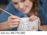 woman making pattern on ceramic vase. Стоковое фото, агентство Ingram Publishing / Фотобанк Лори