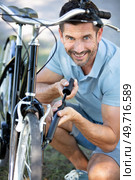 man inflating the tire of a bicycle. Стоковое фото, агентство Ingram Publishing / Фотобанк Лори