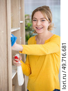 woman dusting the home with a smile. Стоковое фото, агентство Ingram Publishing / Фотобанк Лори