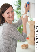 woman cleaning shelf with rag and detergent spray bottle. Стоковое фото, агентство Ingram Publishing / Фотобанк Лори