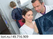 Doctors looking at spinal xray. Стоковое фото, агентство Ingram Publishing / Фотобанк Лори