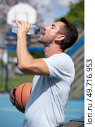 athlete drinking water after a long exhausting basketball game. Стоковое фото, агентство Ingram Publishing / Фотобанк Лори