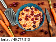 Vitamin salad of grated carrots and gooseberries on wooden background.. Grated carrots salad. Стоковое фото, агентство Ingram Publishing / Фотобанк Лори
