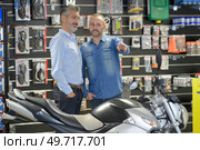 vendor pointing at a specific motorbike. Стоковое фото, агентство Ingram Publishing / Фотобанк Лори