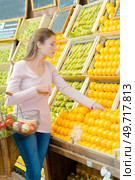 Lady choosing oranges in grocers. Стоковое фото, агентство Ingram Publishing / Фотобанк Лори