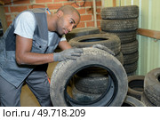 Man examining tread on dismantled tyre. Стоковое фото, агентство Ingram Publishing / Фотобанк Лори