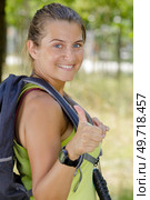 woman hitchhiker with backpack sign thumb up. Стоковое фото, агентство Ingram Publishing / Фотобанк Лори