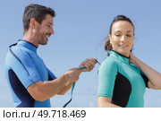 surfing woman and man helping her with wetsuit. Стоковое фото, агентство Ingram Publishing / Фотобанк Лори