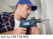man drills a wall. Стоковое фото, агентство Ingram Publishing / Фотобанк Лори