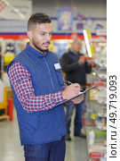 inspecting if there's enough products on the stalls. Стоковое фото, агентство Ingram Publishing / Фотобанк Лори