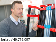 man choosing framing moulding in studio. Стоковое фото, агентство Ingram Publishing / Фотобанк Лори