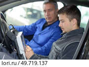 auto mechanic teacher and trainee performing tests at mechanic school. Стоковое фото, агентство Ingram Publishing / Фотобанк Лори
