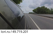 The car is driving along the road at high speed against the background of a cloudy sky. Стоковое видео, видеограф Ярославский Максим / Фотобанк Лори