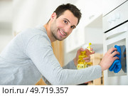 a man cleaning kitchen oven. Стоковое фото, агентство Ingram Publishing / Фотобанк Лори