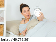 lady looking at alarmclock in disbelief. Стоковое фото, агентство Ingram Publishing / Фотобанк Лори