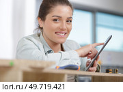 happy woman just moved in new apartment using a tablet. Стоковое фото, агентство Ingram Publishing / Фотобанк Лори
