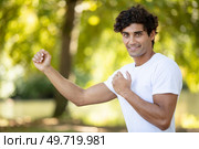 smiling man in martial-arts combat pose. Стоковое фото, агентство Ingram Publishing / Фотобанк Лори