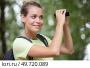 young woman looking through binoculars. Стоковое фото, агентство Ingram Publishing / Фотобанк Лори