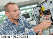 Man working on dismantled computer. Стоковое фото, агентство Ingram Publishing / Фотобанк Лори