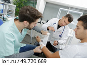 doctor bandaging mans injured hand. Стоковое фото, агентство Ingram Publishing / Фотобанк Лори