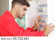 male electrician working on circuit breaker cabinet. Стоковое фото, агентство Ingram Publishing / Фотобанк Лори