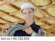 portrait of female builder holding cable conduit. Стоковое фото, агентство Ingram Publishing / Фотобанк Лори