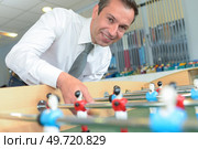 businessman playing table soccer during break. Стоковое фото, агентство Ingram Publishing / Фотобанк Лори
