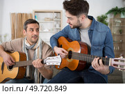 two men playing guitars. Стоковое фото, агентство Ingram Publishing / Фотобанк Лори